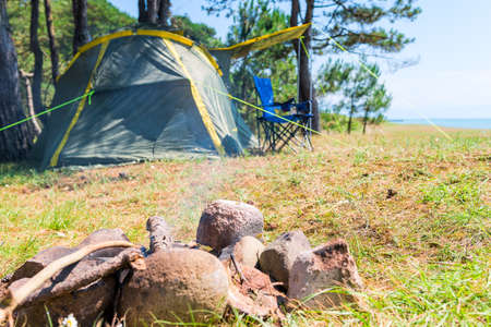 fireplace and camping tent by the sea on a sunny summer dayの写真素材