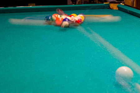 Sports game of billiards on a green cloth. Multi-colored billiard balls with numbers on a pool table