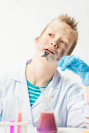 Funny boy dressed as chemist with dirty face after a failed experimentの写真素材