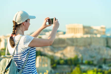 Enjoying vacation in Greece. Young traveling woman enjoying view of Athens city and Acropolis.の写真素材