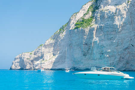 Beautiful sea coast with turquoise water, yacht and rocksの写真素材