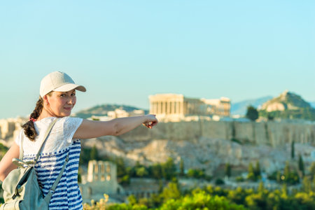 Enjoying vacation in Greece. Young traveling woman enjoying view of Athens city and Acropolis.の写真素材