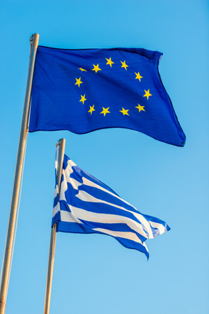 Greece and EU relations. Greek and European Union flags waving on clear blue skyの写真素材