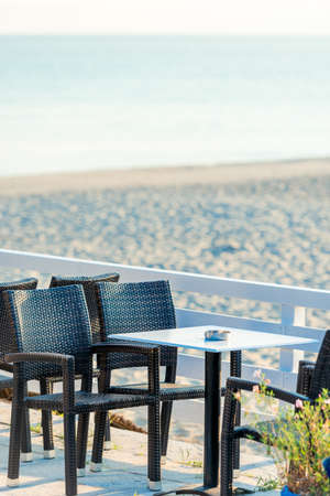 Range of wooden table and black chair for relaxation at restaurant near seaの写真素材