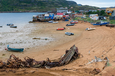 Houses and boats on shore of Barents Sea in Teriberka, Russiaの写真素材