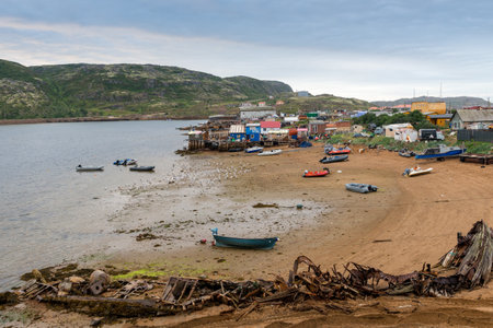 Houses and boats on shore of Barents Sea in Teriberka, Russiaの写真素材