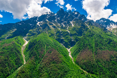 High picturesque green mountains with the remains of melting snow in the mountains of the North...