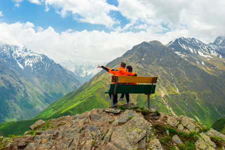 A man and a woman admire the picturesque view of the high mountains of the North Caucasus rangeの写真素材