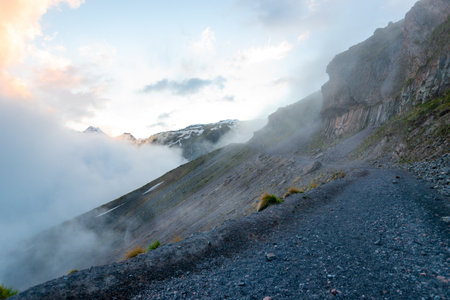 A dangerous mountain trail in the fog on the cliff side. The North Caucasus. Russiaの写真素材