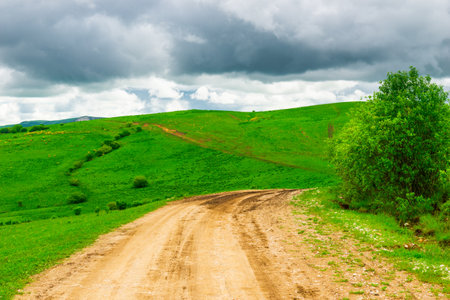 Dirt road on a mountain plateau in a mountainous area in cloudy weatherの写真素材