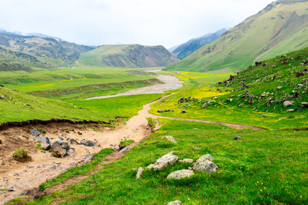 A dramatic scenic landscape with a dirt road descending into the Emmanuel Valley in the Elbrus regionの写真素材
