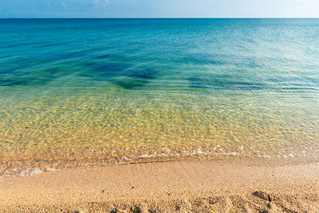 Azure water of a calm sea and a sandy beach in sunny weatherの写真素材
