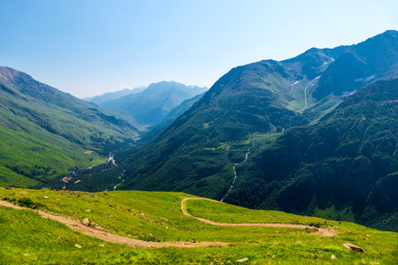Serpentine mountain trail high in the mountains with a view of a picturesque gorge in good weatherの写真素材