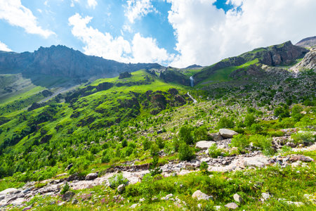 Harsh landscape of rocky green mountain slope in sunny weather. Caucasus, Elbrus region.の写真素材