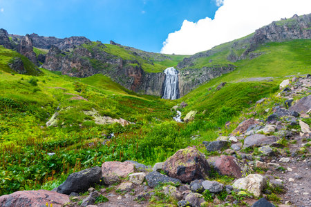Picturesque landscape with beautiful Terskol waterfall, green slopes and steep cliffs. Caucasus, Elbrus region.の写真素材