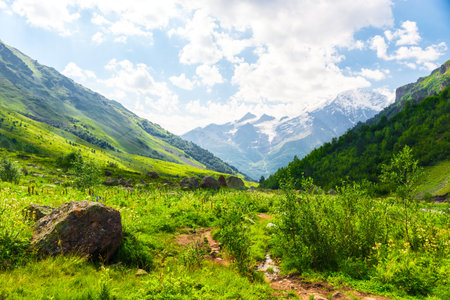 Beautiful high mountain landscape with green slopes and large stones. Caucasus, Elbrus region.の写真素材