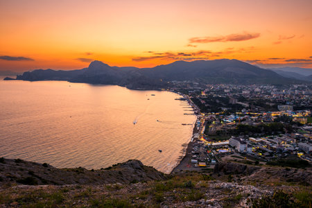 Picturesque view of sunset over the embankment of the city of Sudak in the mountainous area of ââthe southern coast of Crimeaの写真素材