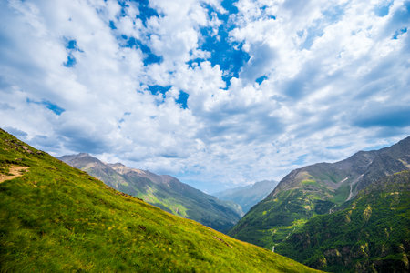 Serpentine mountain trail high in the mountains with a view of a picturesque gorge in good weatherの写真素材