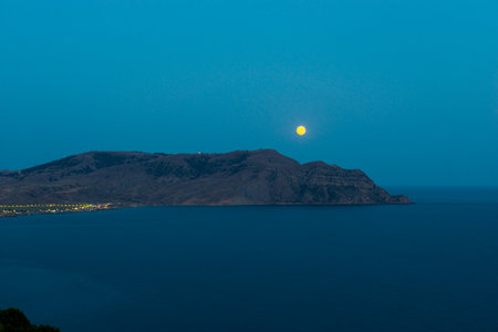 Night picturesque landscape with a sea cape and a rising moon. Southern coast of the Crimean peninsula. Russiaの写真素材