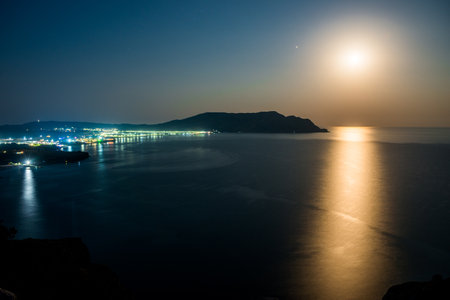 Night picturesque seascape with rising moon and moon path. South coast of Crimea peninsula. Russiaの写真素材