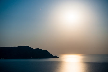 Night picturesque seascape with rising moon and moon path. South coast of Crimea peninsula. Russiaの写真素材