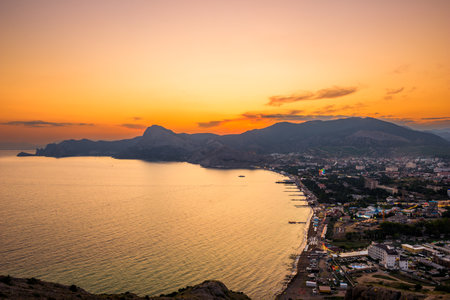 Picturesque view of sunset over the embankment of the city of Sudak in the mountainous area of ââthe southern coast of Crimeaの写真素材
