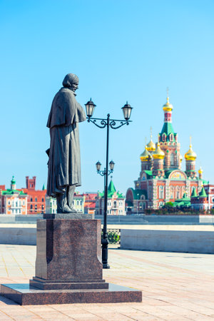 Statue of the writer Nikolai Vasilyevich Gogol against the backdrop of the Cathedral of the Annunciation of the Blessed Virgin Mary in Yoshkar-Olaの写真素材