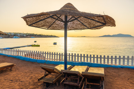 Straw beach umbrella with sun loungers on the shore of the Red Seaの写真素材