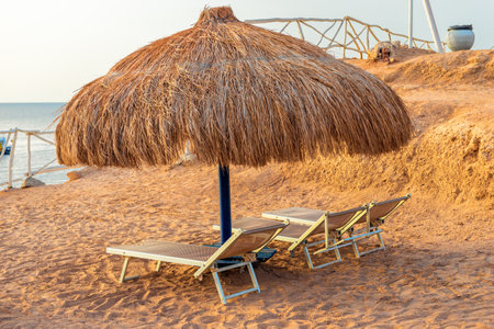 Straw beach umbrella with sun loungers on the shore of the Red Seaの写真素材