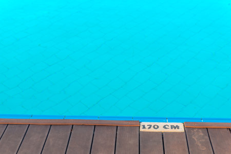 Depth mark at the edge of a pool with clear azure waterの写真素材