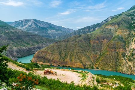 Picturesque landscape of Sulak canyon in the mountains of the North Caucasus of Dagestan with construction equipment on a dirt road. Russiaの写真素材