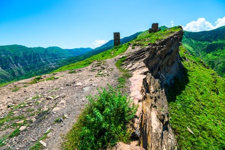 Picturesque mountain landscape with ruins of ancient towers on a steep cliff. North Caucasus