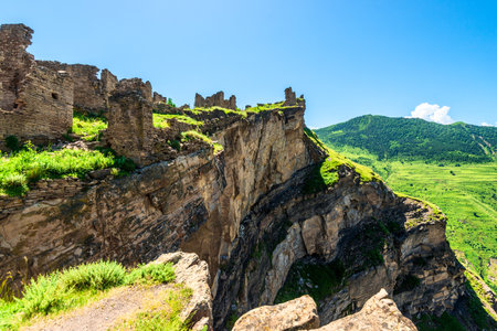 A dramatic view of the ruins of the mountain village of Goor above the abyss of a deep mountain gorge in the North Caucasusの写真素材