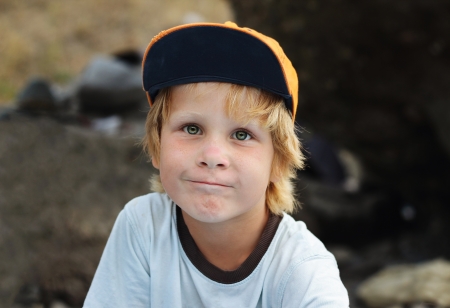 Closeup portrait of cheerful little boy with green eyes  in capの写真素材