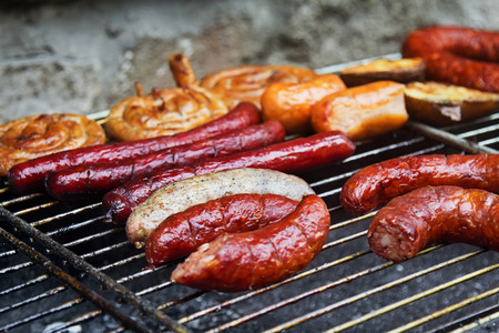 Assortment of grilled sausages and wurst on big grill. Selective focus on the white sausage.の写真素材
