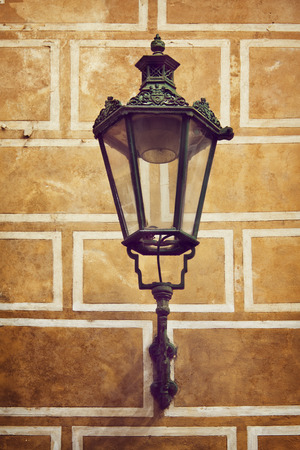 Ancient street lantern lamp on the yellow wall backgroundの写真素材