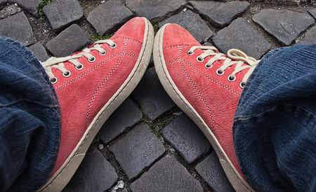 Feet in red sneakers and jeans outdoors. Making first step.の写真素材