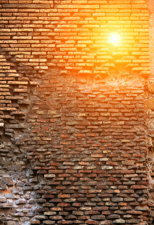 Red brick wall with  lop-sided rustication, texture grunge background, sun shoot through wallの写真素材