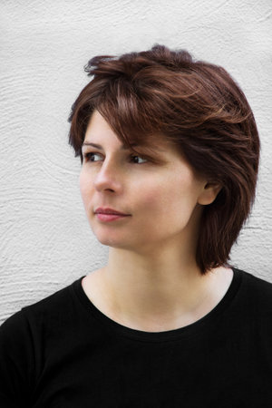 Portrait of dreamy beautiful young woman with brown hair on white wall background. Natural beauty.の写真素材