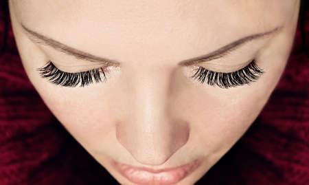 Eyelash extension procedure. Close-up woman's eyes with long false eyelashes. Top view.の写真素材