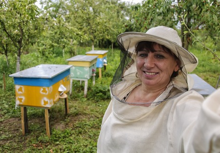 woman beekeeper making selfie near beehives apiaryの写真素材