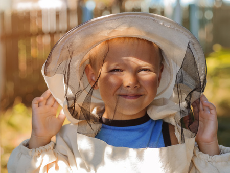 portrait of a boy in a beekeeper protective clothing