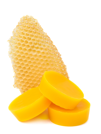 Pieces of natural beeswax and a piece of honey cell are isolated on a white background. Beekeeping products. Apitherapy.の写真素材