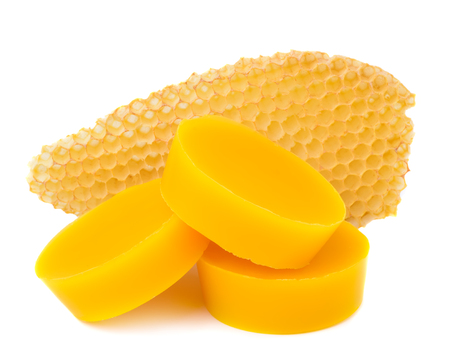 Pieces of natural beeswax and a piece of honey cell are isolated on a white background. Beekeeping products. Apitherapy.の写真素材