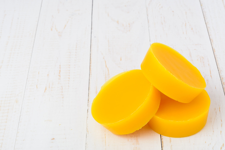 Pieces of natural beeswax on a wooden background. Beekeeping products. Apitherapy.の写真素材