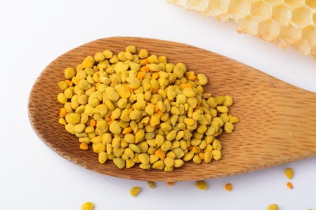 Bee pollen in a wooden spoon and a honeycomb. Beekeeping products. Apitherapyの写真素材