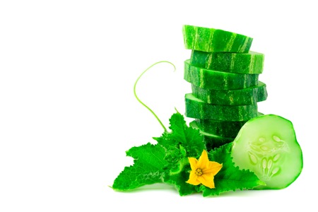 A stack of green cucumber slices with leaves on a white backgroundの写真素材