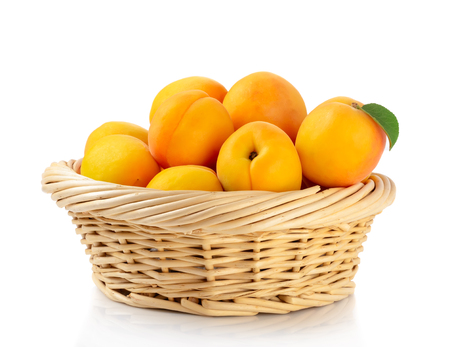 Fresh apricots in the basket are isolated on a white background.の写真素材