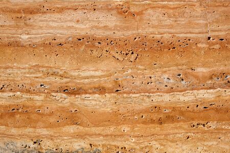 Wall of travertine with stone layers of different colors. Close up architecture macro photography....