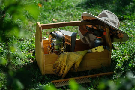A tool of the beekeeper. Everything for a beekeeper to work with bees. Smoker, a chisel, a box, beekeeper suit for protection from the bees. Beekeeping equipment. Photo on the topic of beekeeping.の写真素材
